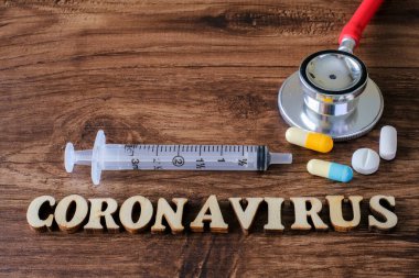 Tahta arka planda tıbbi ekipmanlarla Coronavirus yazıları. Roman Coronavirus 2019-nCoV Orta Doğu Solunum Sendromu Coronavirüs.