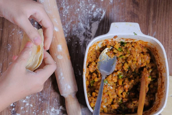 Woman making curry puff.