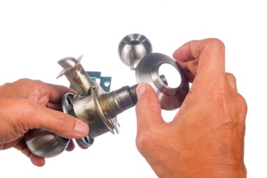 Beyaz arka planda izole edilmiş kapı tokmağını birleştiren işçi ellerinin yakın çekimi.