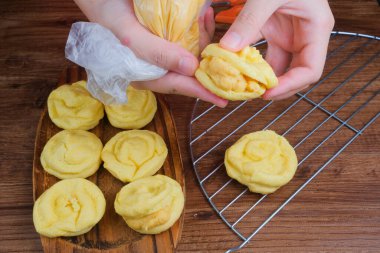 Boru torbasını kullanarak kremalı pasta yapan kızın yakın görüntüsü.