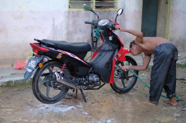Muadzam Şah, Malezya - 17 Haziran 2020: Batı Malezya 'nın İlk Halkı (Orang Aslı) motosikletini temizleyip yıkıyor