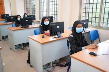 Muadzam Şah, Malezya - 29 Haziran 2020: Yeni Normal Kavram 'da sosyal uzaklık, Öğretmen, Oğlan ve Yüzü maskeli kız Sınıfta yaşıyor. Corona virüsü veya COVID-19 salgınını önle.