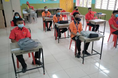Muadzam Shah, Malaysia - June 29th,2020: Social distance in New Normal Concept, Teacher , Boy and girl wearing medical face mask live in Classroom. prevent pandemic of corona virus or COVID-19. clipart