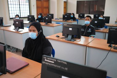 Muadzam Shah, Malaysia - June 29th,2020: Social distance in New Normal Concept, Teacher , Boy and girl wearing medical face mask live in Classroom. prevent pandemic of corona virus or COVID-19. clipart
