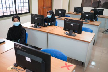 Muadzam Şah, Malezya - 29 Haziran 2020: Yeni Normal Kavram 'da sosyal uzaklık, Öğretmen, Oğlan ve Yüzü maskeli kız Sınıfta yaşıyor. Corona virüsü veya COVID-19 salgınını önle.