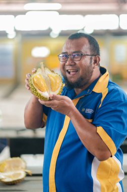 Muadzam Şah, Malezya - 29 Haziran 2020: Mutlu Asyalı erkekler arkadaşlarıyla Durian meyvesi yemekten hoşlanıyor.