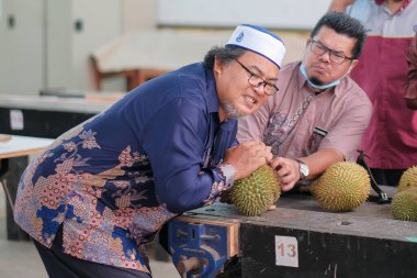 Muadzam Şah, Malezya - 25 Haziran 2020: Mutlu Asyalı erkekler arkadaşlarıyla Durian meyvesi yemekten hoşlanıyor.