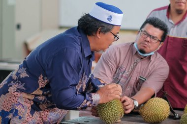 Muadzam Şah, Malezya - 25 Haziran 2020: Mutlu Asyalı erkekler arkadaşlarıyla Durian meyvesi yemekten hoşlanıyor.