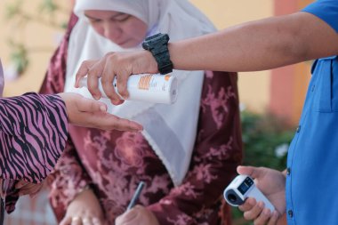 Muadzam Şah, Malezya - 29 Haziran 2020: Yeni normal, el dezenfektanı, sağlık hizmetleri ve covid-19 önleme kavramı kullanan iş adamları