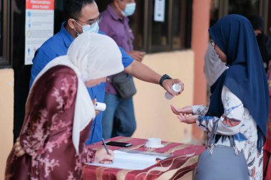 Muadzam Şah, Malezya - 29 Haziran 2020: Yeni normal, el dezenfektanı, sağlık hizmetleri ve covid-19 önleme kavramı kullanan iş adamları