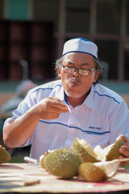 Muadzam Şah, Malezya - 1 Temmuz 2020: Mutlu Asyalı erkekler arkadaşlarıyla Durian meyvesi yemekten hoşlanırlar.