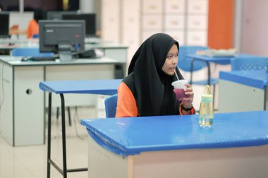 Muadzam Şah, Malezya - 25 Haziran 2020: Öğrenci sınıfta yemek yiyor. Sosyal uzaklık. Corona virüsünün veya covid-19 'un korunması kavramını kabul et.