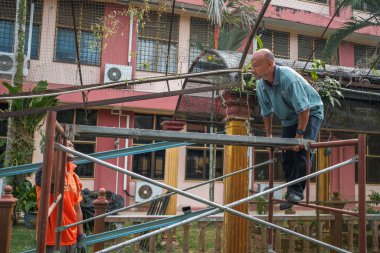 Muadzam Şah, Malezya - 7 Temmuz 2020: Çatı iskelesine başlamadan önce iki işçi iskeleyi birleştiriyor