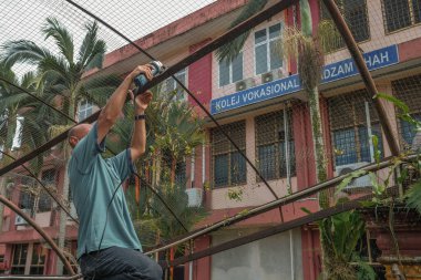 Muadzam Şah, Malezya - 7 Temmuz 2020: Metal çatı iskeleti kesmek için öğütme makinesi kullanan işçi