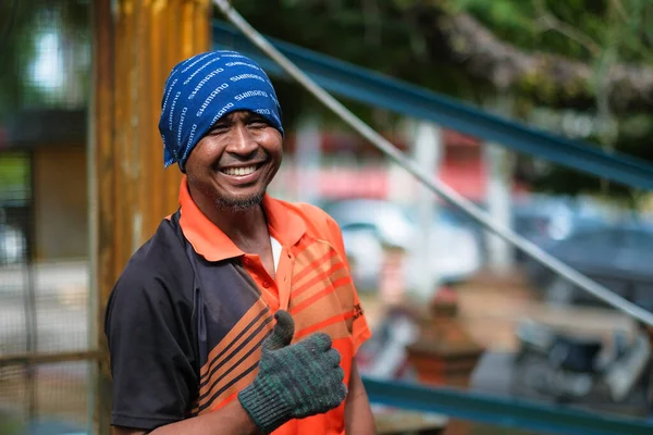 Muadzam Şah, Malezya - 7 Temmuz 2020: Metal çatı iskeleti kesmek için öğütme makinesi kullanan işçi