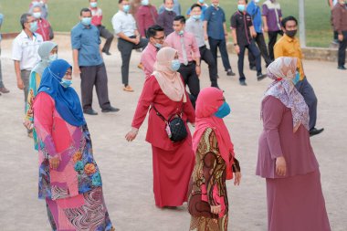 Muadzam Şah, Malezya - 13 Temmuz 2020: Yüzü maskeli öğretmenler her sabah işten önce okulda esnetiyorlar .