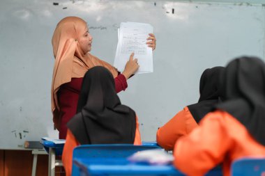 Muadzam Şah, Malezya - 8 Temmuz 2020: Soruya cevap veren öğrencisine gülümseyen Müslüman öğretmen