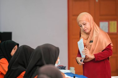 Muadzam Şah, Malezya - 8 Temmuz 2020: Soruya cevap veren öğrencisine gülümseyen Müslüman öğretmen