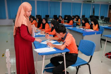 Muadzam Şah, Malezya - 8 Temmuz 2020: Soruya cevap veren öğrencisine gülümseyen Müslüman öğretmen