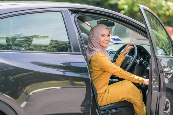 İş seyahatinde tesettürlü bir iş kadını bavulu bagaja koyar..