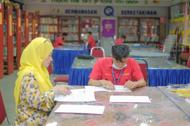 Muadzam Şah, Malezya _ 12 Ağustos 2020: Öğretmen ve öğrenciler kütüphanede birlikte okuyorlar