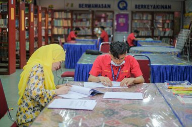 Muadzam Şah, Malezya _ 12 Ağustos 2020: Öğretmen ve öğrenciler kütüphanede birlikte okuyorlar