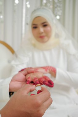 Malezyalı düğün çifti, eline yüzük takıyor. Seçici Odaklanma ve Sığ DOF.