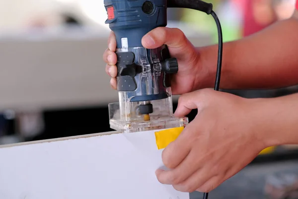 Genç marangoz kenar şeritleri kesmek için katmanlı budama makinesi kullanıyor. .