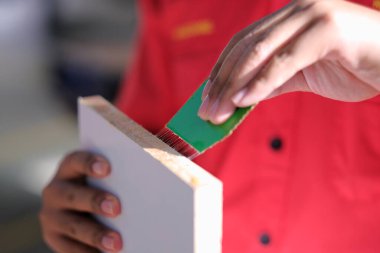 Genç marangoz dolaba kenar şeritleri yerleştiriyor..