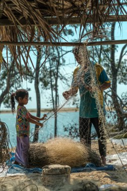 Kuala Rompin, Malezya - 30 Ağustos 2020: Günün taze avından sonra balıkçılar balık ağlarını toplayıp temizliyorlar.