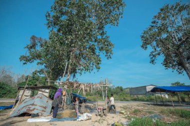 Kuala Rompin, Malezya - 30 Ağustos 2020: anne ve baba balıkçı iskelesinden taze yengeç alıyor.