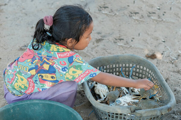 Куала-Ромпин, Малайзия - 30 августа 2020 года: Молодая азиатская девочка и краб в рыбацкой деревне Куала-Ромпин