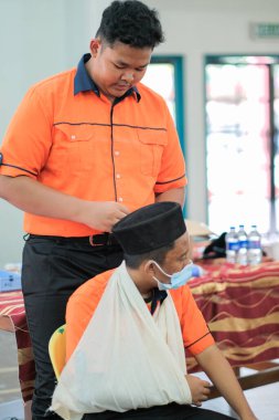 Muadzam Şah, Malezya - 2 Eylül 2020: Öğrenci ilk yardım eğitimi salonu. Kolejde bir hastanın kırık kolunu elastik bandajla sarmaya çalışan bir öğrenci..