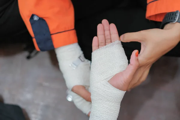Student first aid training in the hall. Student trying to splint the hand  of a patient\'s broken hand incident with elastic bandage in college.