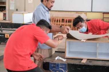 Muadzam Şah, Malezya - 3 Eylül 2010: Marangoz ev dekorasyonu için bir televizyon mobilyasına lamine tezgah kuruyor