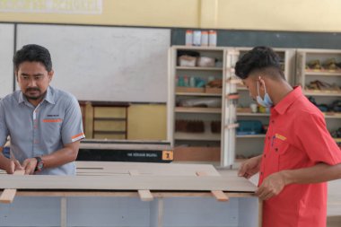 Muadzam Şah, Malezya - 3 Eylül 2010: Marangoz ev dekorasyonu için bir televizyon mobilyasına lamine tezgah kuruyor