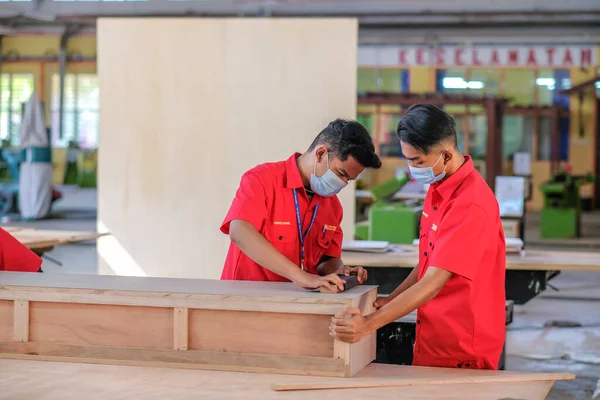 Muadzam Şah, Malezya - 1 Eylül 2020: Atölye atölyelerindeki dolaplara lamine döşeyen genç marangozlar