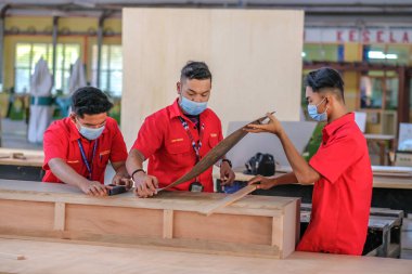 Muadzam Şah, Malezya - 1 Eylül 2020: Atölye atölyelerindeki dolaplara lamine döşeyen genç marangozlar