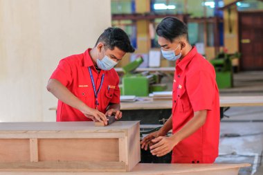 Muadzam Şah, Malezya - 1 Eylül 2020: Atölye atölyelerindeki dolaplara lamine döşeyen genç marangozlar