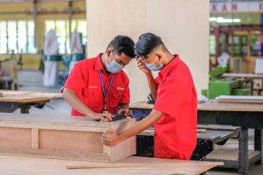 Muadzam Şah, Malezya - 1 Eylül 2020: Atölye atölyelerindeki dolaplara lamine döşeyen genç marangozlar