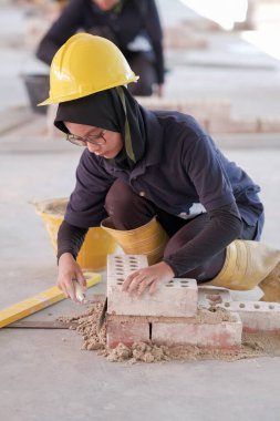Besut, Malezya - 8 Eylül 2020: Tuğla duvar inşaatında çalışan üniversite öğrencileri