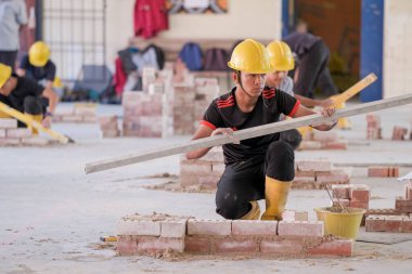 Besut, Malezya - 8 Eylül 2020: Tuğla duvar inşaatında çalışan üniversite öğrencileri