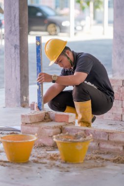 Besut, Malaysia - September 8th, 2020 : College students using spirit level in bricklaying workshop clipart