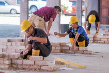 Besut, Malezya - 8 Eylül 2020: Tuğla duvar inşaatında çalışan üniversite öğrencileri