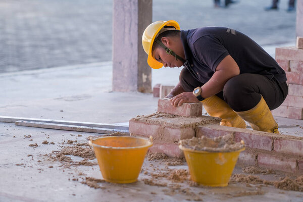 Фатут, Малайзия - 8 сентября 2020 года: студенты колледжа, работающие на строительстве кирпичных стен в цехе кирпичной кладки