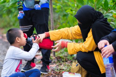 Muadzam Şah, Malezya - 13 Eylül 2020: Malezya 'nın Muadzam Şah kentindeki Ridan Tepesi' nin tepesinde yürüyüş yapan aile yemek yiyor. Tatilde aile yürüyüşü..