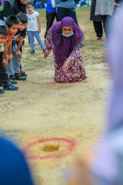 Muadzam Şah, Malezya - 16 Eylül 2020: Malezya Günü 'nde sahada bilye oyunu adı verilen geleneksel oyunlar oynayan insanlar