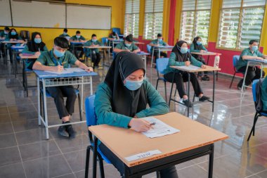 Muadzam Şah, Malezya - 8 Temmuz 2020: Malezyalı öğrenciler Covid -19 'dan korunmak için okulda yüz maskesi ve yüz maskesi takıyorlar. Yeni normal eğitim.