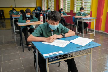 Muadzam Şah, Malezya - 8 Temmuz 2020: Malezyalı öğrenciler Covid -19 'dan korunmak için okulda yüz maskesi ve yüz maskesi takıyorlar. Yeni normal eğitim.