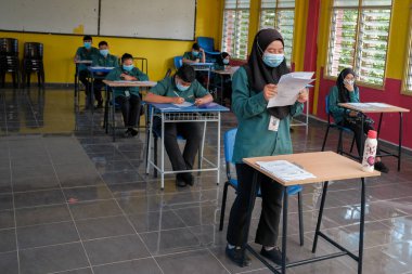 Muadzam Şah, Malezya - 8 Temmuz 2020: Malezyalı öğrenciler Covid -19 'dan korunmak için okulda yüz maskesi ve yüz maskesi takıyorlar. Yeni normal eğitim.